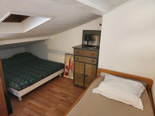 - une petite chambre avec un lit et une commode dans l'établissement Cocoon La Londe M2, à La Londe-les-Maures