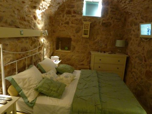 a bedroom with a bed in a stone wall at St. George Sykoussis Traditional Residence in Ágios Geórgios Sykoúsis
