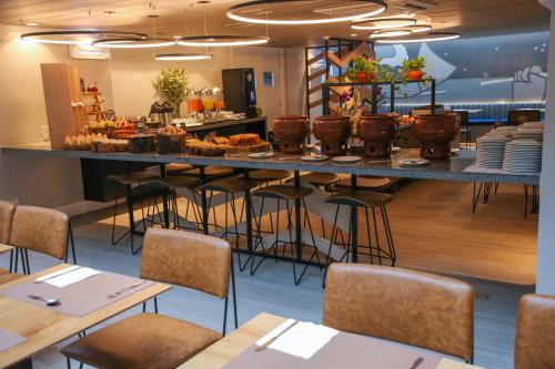 um restaurante com um bar e mesas e cadeiras em Mercure Maceio Pajuçara em Maceió