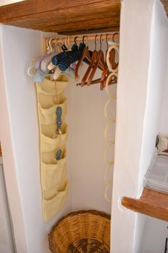 a room with a closet with shoes and a basket at PYRGALI ΠΕΤΡΙΝΟ ΠΥΡΓΑΚΙ ΠΑΤΜΟΣ in Skala