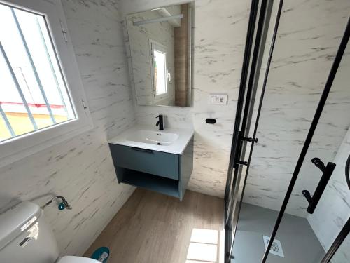 a white bathroom with a sink and a mirror at Apartamento Chipiona Playa in Chipiona