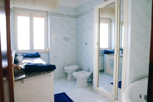 a bathroom with a toilet and a sink and a shower at LA CASA DI FLO in Anzio