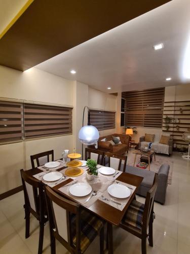 a dining room with a table and a living room at Serenity Home near Ayala Malls Serin in Tagaytay