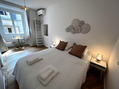 a bedroom with a large white bed with two pillows at Le Petit Palais Notre Dame - Heart of Dijon - With AC in Dijon