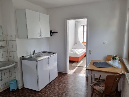 a kitchen with a sink and a table in a room at Boutiquehotel Goldene Rose - self-check-in in Rothenburg ob der Tauber