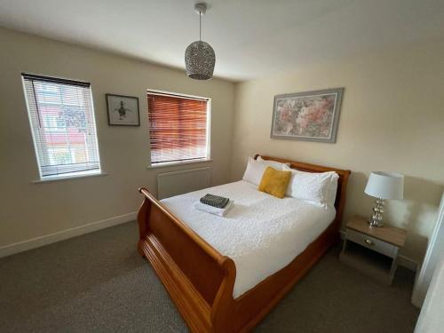 a bedroom with a bed and two windows at Imperial way Ashford TN23 in Kent