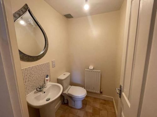 a bathroom with a toilet and a sink and a mirror at Imperial way Ashford TN23 in Kent