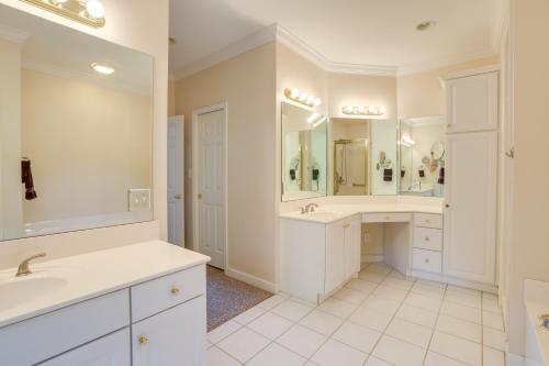 La salle de bains est pourvue de 2 lavabos et d'un grand miroir. dans l'établissement Sunny Coosa River Hideaway with Boat Dock and Slip!, 