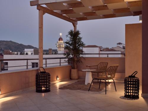 a balcony with chairs and a table and a lighthouse at Laura Suites in Zakynthos Town