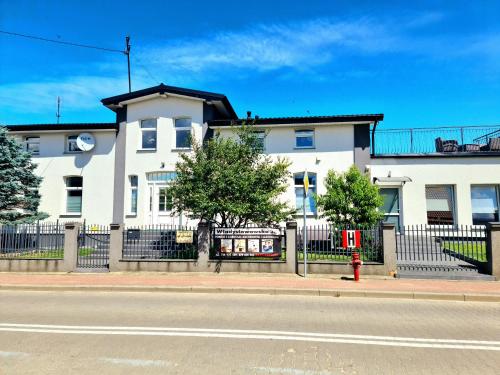 a white house with a fence and a red fire hydrant at Władysławowska 36 - domki i pokoje gościnne in Władysławowo
