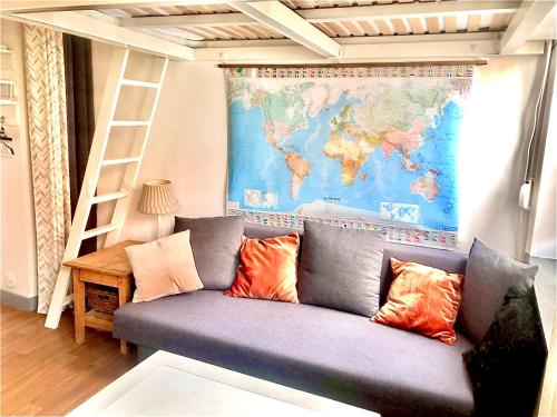 - un canapé dans une chambre avec une carte sur le mur dans l'établissement Cocon avec cour citadelle Vauban, à Lille