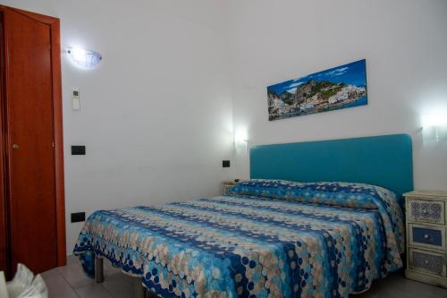 a bedroom with a bed with a blue bedspread at Palazzo Carafa della Spina in Naples