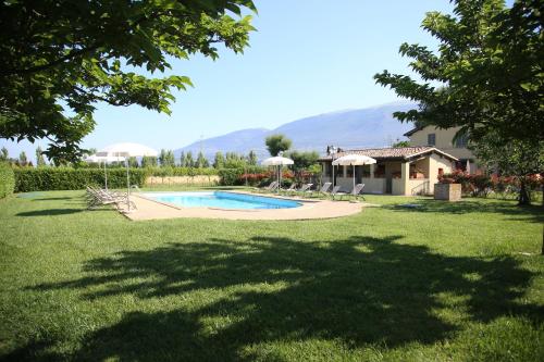 un patio con piscina y una casa en Residenza Isabella en Spello