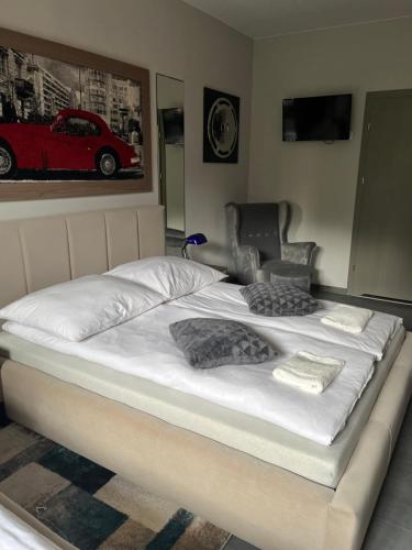 a bed with white sheets and pillows on it at Spalskie Pokoje Gościnne in Spała
