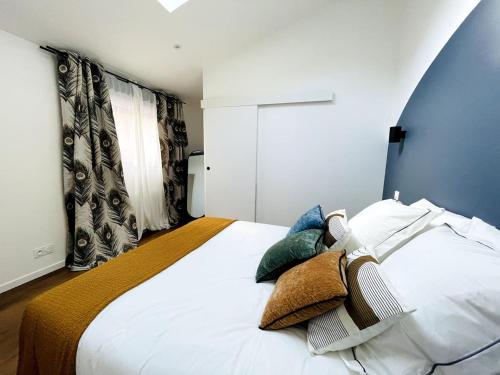 een slaapkamer met een groot wit bed met kussens bij Loft - Centre Ville in Brest