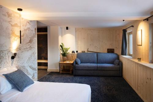 1 dormitorio con 1 cama y 1 sofá azul en Miroir d'Argentine en Gryon