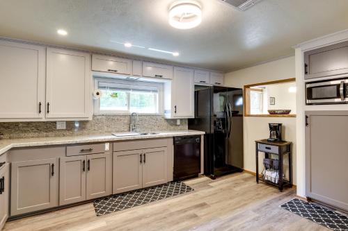 a kitchen with white cabinets and a black refrigerator at Lakefront College Station Home Near Texas A and M! in College Station