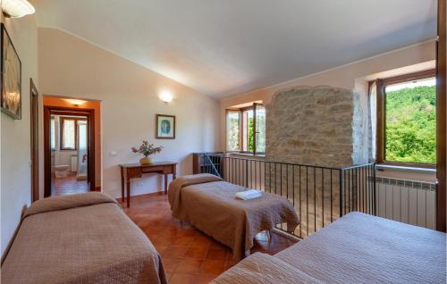 a room with two beds and a stone wall at Valguerriera - Rosa Bianca in Apecchio