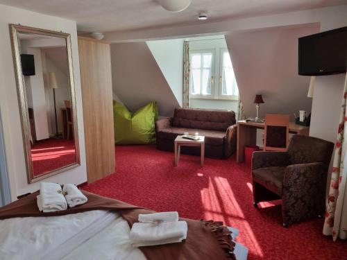 a hotel room with a bed and a living room at Boutiquehotel Goldene Rose - self-check-in in Rothenburg ob der Tauber