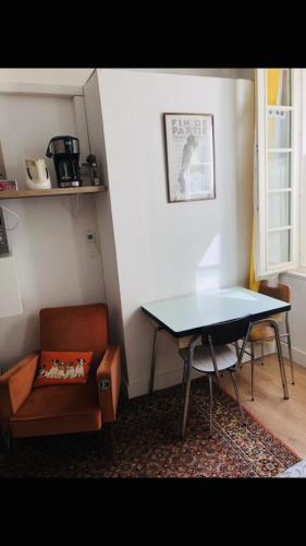 Cette chambre dispose d'une table, d'une chaise, d'une table et d'un canapé. dans l'établissement Bulles Champagne Troyes Bouchon, à Troyes