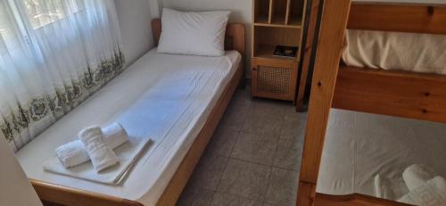 a small bedroom with a bed with two towels at Pefkochori Family Spot in Pefkohori