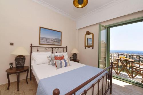 a bedroom with a bed with a view of the ocean at Απεριόριστη Θέα δίπλα στην πόλη in Ano Syros