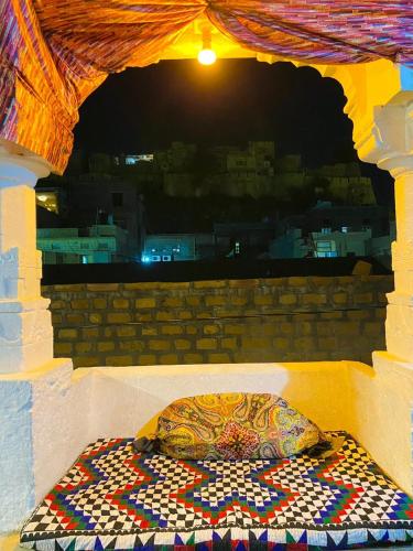 a pillow sitting on a bed in a room at Mirvana Guest House & Camel safari in Jaisalmer