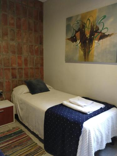 een slaapkamer met een bed en een schilderij aan de muur bij Kairós 2 - Departamentos Temporarios Santa Fe in Santa Fe
