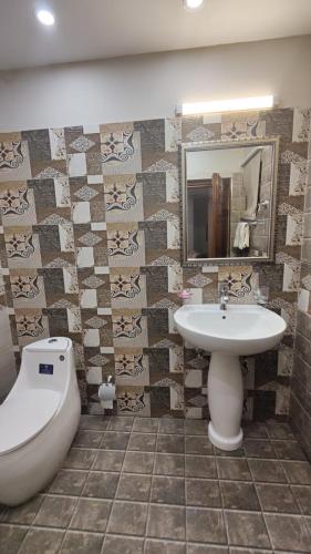 a bathroom with a sink and a tub and a toilet at Hotel white season Gulberg in Lahore