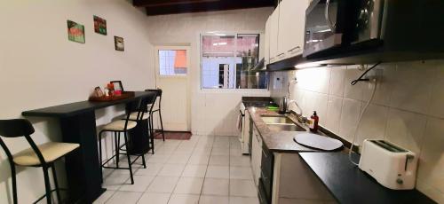 a small kitchen with a sink and a counter at CASA CÉNTRICA RIOJA ,Patio Parrilla, Zona Residencial, Parking privado gratis a 100 mts in Mendoza
