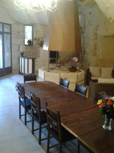 a large dining room with a large wooden table and chairs at Le Manoir des Roches in Bourré