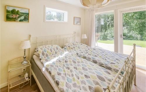 Stunning Home In Tvrred With Kitchen في Alhammar: سرير في غرفة نوم مع نافذة كبيرة
