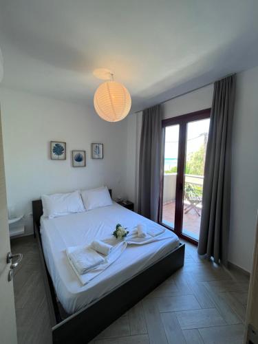 a bedroom with a large white bed and a window at Elena Limnos Beach in Volissos