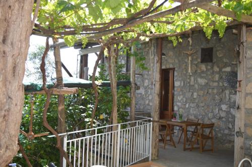 ein Steinhaus mit einem Tisch und Stühlen auf einer Veranda in der Unterkunft La Petra in Vico Equense