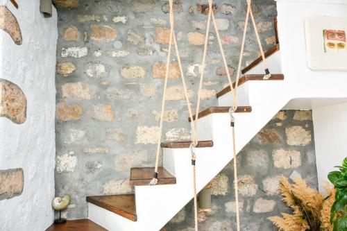 a staircase in a room with a stone wall at PYRGALI ΠΕΤΡΙΝΟ ΠΥΡΓΑΚΙ ΠΑΤΜΟΣ in Skala
