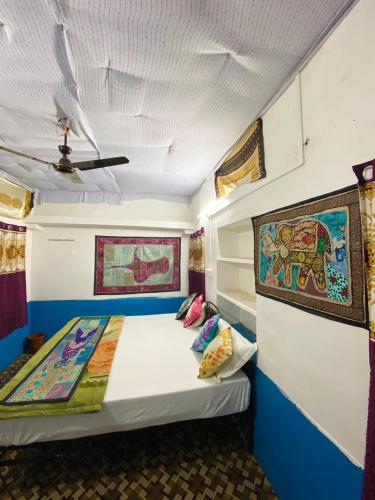 a bed in a room with a painting on the wall at Mirvana Guest House & Camel safari in Jaisalmer