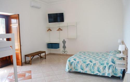 1 dormitorio con 1 cama y TV en la pared en La Petra, en Vico Equense
