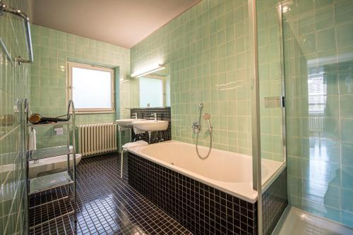 y baño con bañera, ducha y lavamanos. en Villa Vastle, en Ortisei