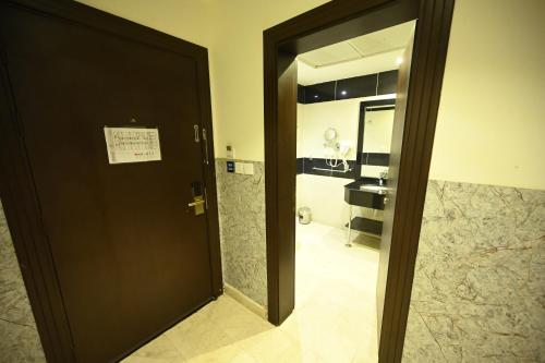 a door leading to a bathroom with a sink at Aster Hotel in Jeddah