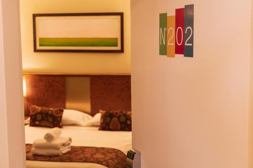 a hotel room with two beds and a picture on the wall at 1412 Hotel Boutique in Rosario