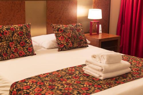 a hotel room with a bed with towels on it at 1412 Hotel Boutique in Rosario