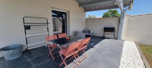 a patio with a table and chairs on a patio at Adorable gîte au calme in Angliers