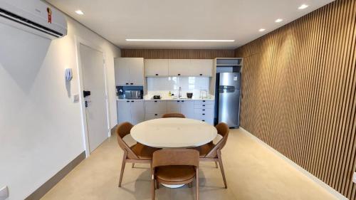 uma cozinha com uma mesa e cadeiras e um frigorífico em Loft Confortável e Luxuoso ao lado do Shopping CG. em Campo Grande