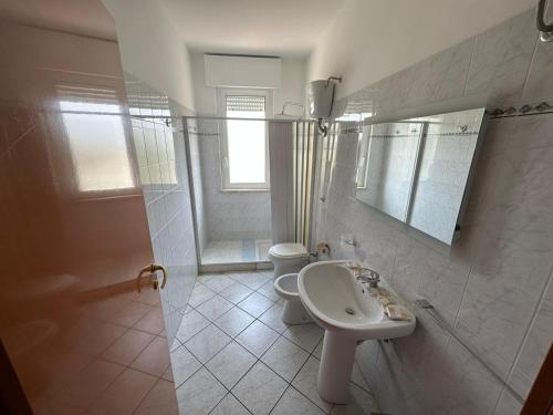 ein weißes Bad mit einem Waschbecken und einem WC in der Unterkunft Ariosto House in Porto Cesareo
