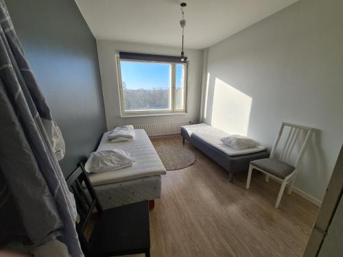 een kamer met een bed, een stoel en een raam bij Rytitornit Apartment A18 in Kemi