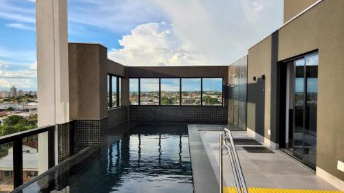 una piscina en medio de un edificio en Loft Confortável e Luxuoso ao lado do Shopping CG., en Campo Grande