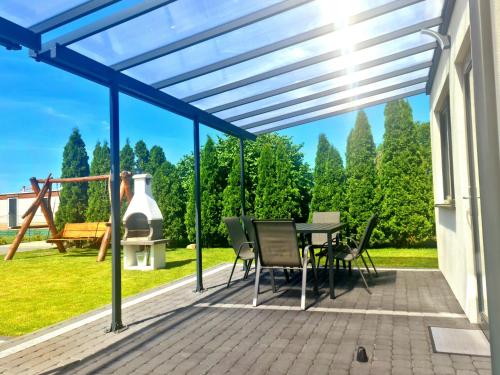 a patio with a table and chairs and a view of trees at Władysławowska 36 - domki i pokoje gościnne in Władysławowo
