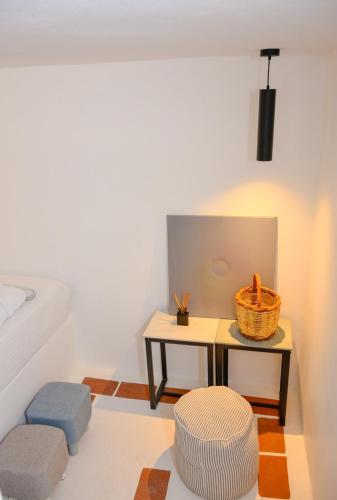 a room with a table and two stools and a basket at PYRGALI ΠΕΤΡΙΝΟ ΠΥΡΓΑΚΙ ΠΑΤΜΟΣ in Skala