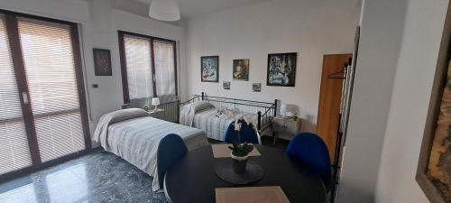 a hospital room with two beds and a table at Casa Santa Maria Maddalena in Ferrara