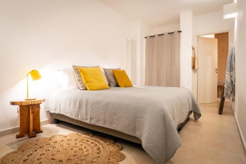 1 dormitorio con 1 cama con almohadas amarillas y alfombra en Villa Gufo, en Ostuni